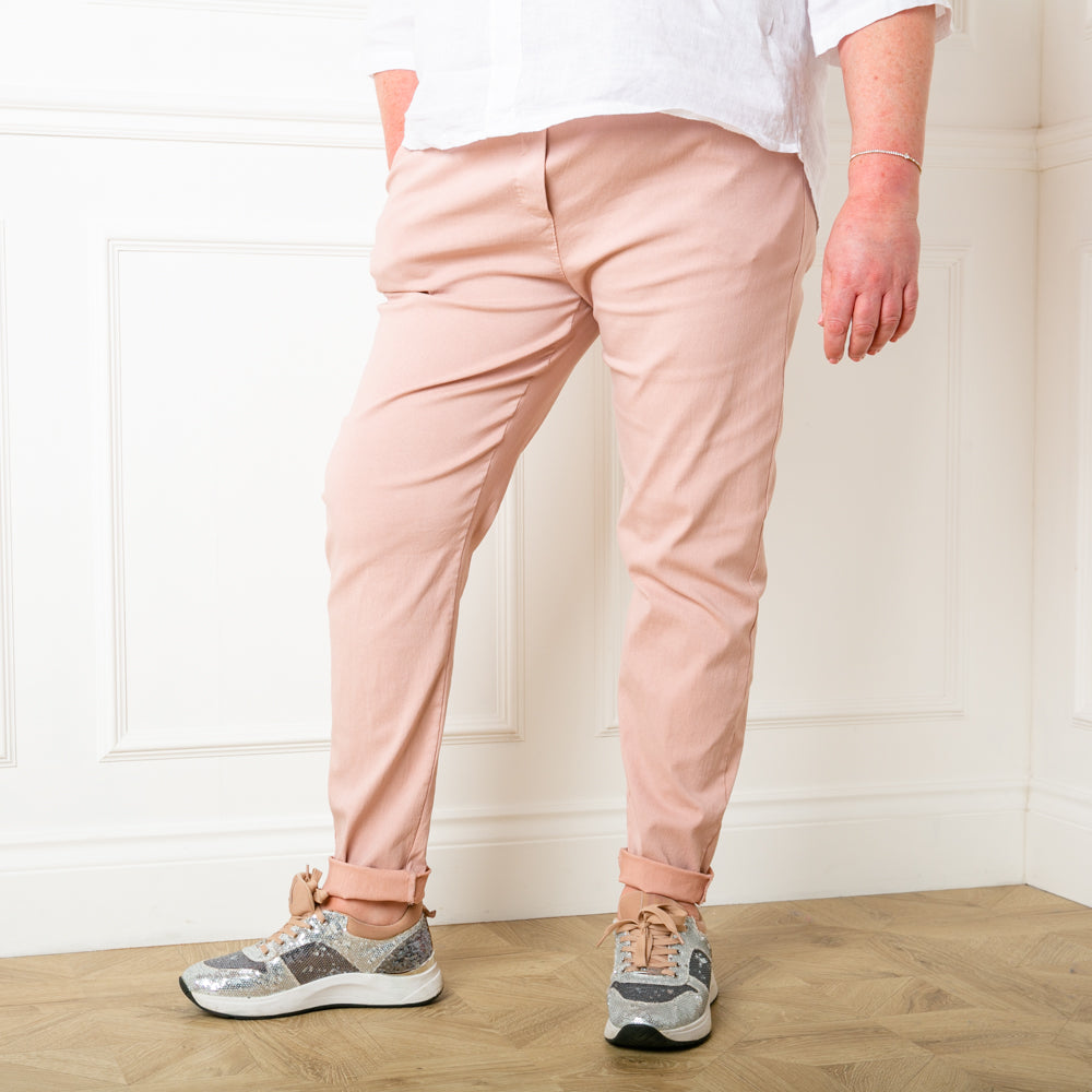 Plus size stretch trousers in blush pink with pockets on either side. The bottom hem can be rolled up to any length 